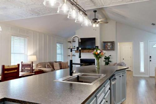 a kitchen with a sink and a living room at Charming Remodeled Home with Modern Comforts Near TAMU & Downtown in Bryan, Texas in Bryan
