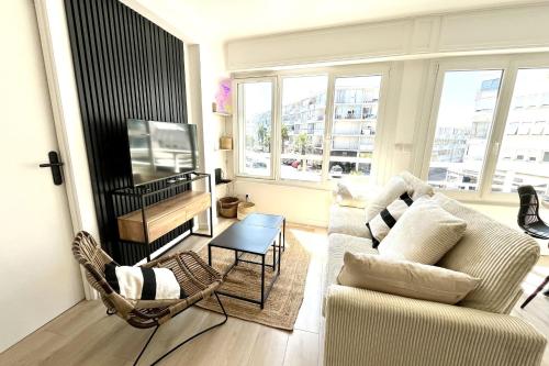 a living room with a couch and a table at Seaside getaway serenity and comfort in Palavas-les-Flots