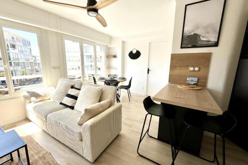 a living room with a couch and a table at Seaside getaway serenity and comfort in Palavas-les-Flots