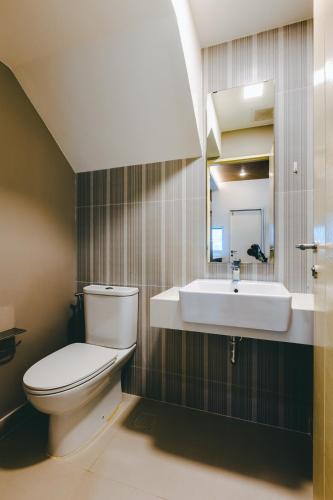 a bathroom with a white toilet and a sink at Beautiful private house in Samutprakarn