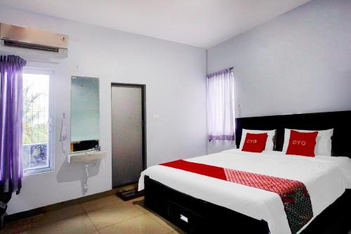 a bedroom with a large bed with red pillows at OYO 94787 Hotel Mulana in Banda Aceh
