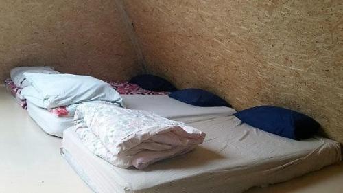 an unmade bed with pillows and sheets on it at Kakulaane Tourism Farm in Lauküla