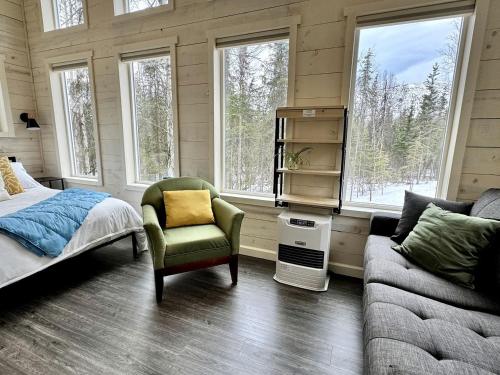 a bedroom with a bed and a chair and a couch at Secluded Cozy Wooden Cabin in Anchorage, Alaska in Chugiak