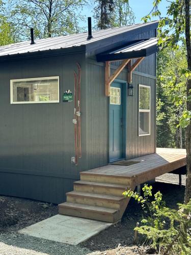a tiny house with a porch and a staircase at Incredible Cabin Surrounded by Trees and Hot-tub Provided in Anchorage, Alaska in Chugiak