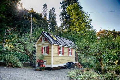 a small yellow tiny house in a garden at Adorable Rural Tiny House Rental on the Puget Sound in Olympia, Washington in Beachcrest
