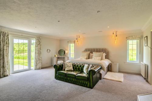 Un dormitorio con una cama y un sofá y ventanas. en Finest Retreats - Grassyards House, en Skelmorlie