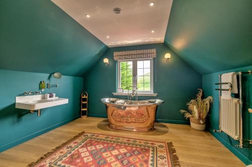 Un baño con una bañera grande y un lavabo. en Finest Retreats - Grassyards House, en Skelmorlie