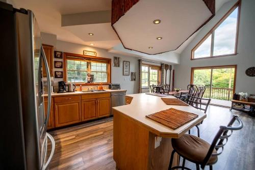 a kitchen with wooden floors and a kitchen island with chairs at Incredible New York Cabin with a Spa and Movie Theater in Livingston Manor