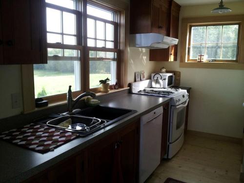 a kitchen with a sink and a stove at Idyllic Cottage Rental near Mount Mansfield State Forest, Vermont in Hardwick
