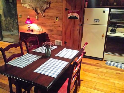 a kitchen with a table and a refrigerator and a table and chairs at Charmingly Rustic Weekend Getaway in the Mountains near Pittsburgh, Pennsylvania in Champion