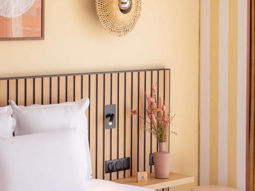 a bedroom with a bed and a vase with flowers at Mercure Nice Centre Notre Dame in Nice