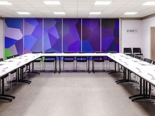 a conference room with tables and chairs and purple walls at Mercure Nice Centre Notre Dame in Nice