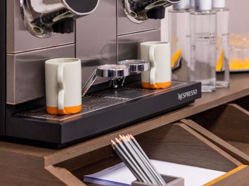 a coffee machine with two cups on a counter at Mercure Nice Centre Notre Dame in Nice