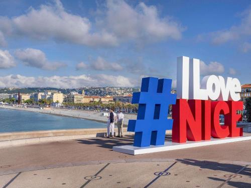 a sign with the words love and nice on a beach at Mercure Nice Centre Notre Dame in Nice