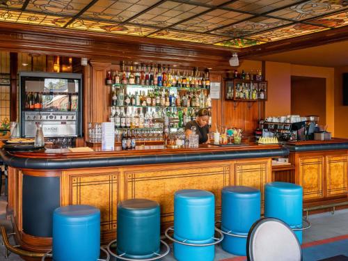 a bar with a man behind the counter at Mercure Lyon Centre Château Perrache in Lyon