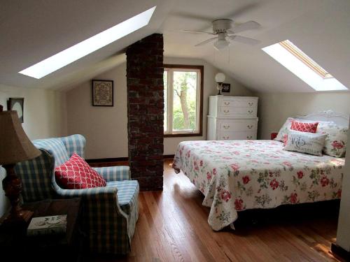 a bedroom with a bed and a chair and a ceiling fan at Serene Countryside Cottage Rental with Screened Porch near Charlottesville, Virginia in Byrd Mill