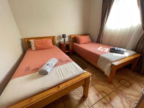 two beds sitting next to each other in a room at Bush Lovers Lodge in Modimolle