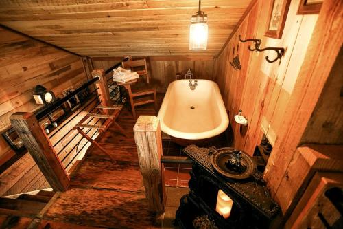 ein Badezimmer mit Badewanne und Waschbecken in der Unterkunft Luxury Cabin for Two with Beautiful River Views near Knoxville in Greeneville