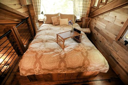 ein Schlafzimmer mit einem Bett in einer Holzhütte in der Unterkunft Luxury Cabin for Two with Beautiful River Views near Knoxville in Greeneville