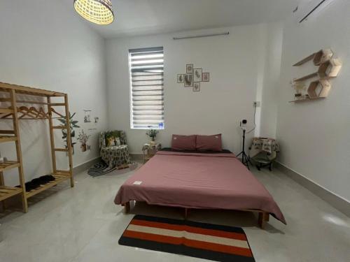 a bedroom with a bed in a white room at Nhi Homestay Rạch Giá in Rach Gia