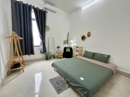 a bedroom with a green bed in a room at Nhi Homestay Rạch Giá in Rach Gia