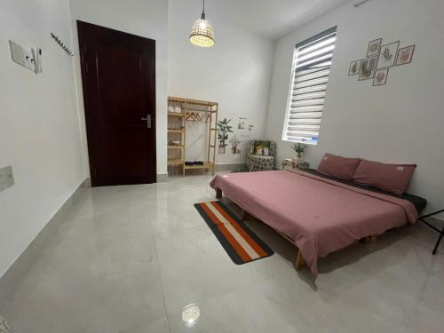 a bedroom with a large pink bed in a room at Nhi Homestay Rạch Giá in Rach Gia
