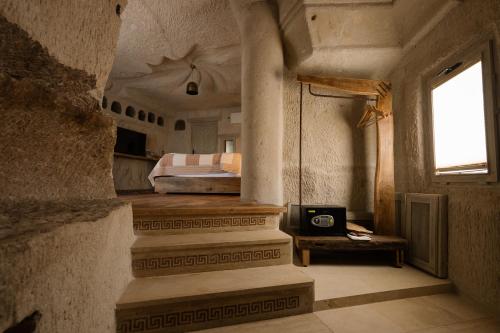 a bedroom with a bed and a table with a clock at Cappadocia Cave Suites Adult Only in Goreme