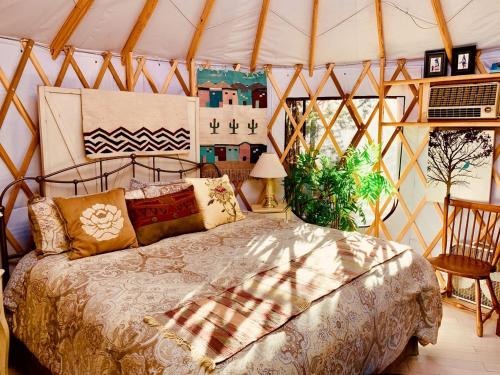 a bedroom with a bed in a tent at Charming Yurt in the Cibola National Forest near Albuquerque, New Mexico in Tijeras