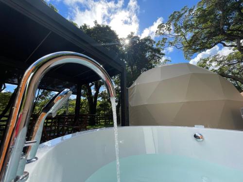 a bath tub with water coming out of it at GLAMFOREST Okinawa 名護 in Nago