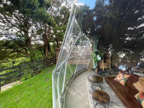 a glass screen on a patio with two stools at GLAMFOREST Okinawa 名護 in Nago
