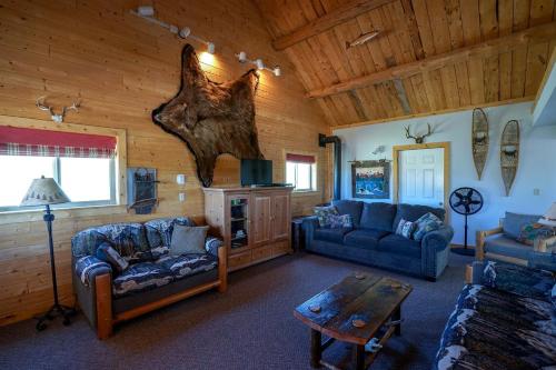 a living room with couches and a table in a cabin at Adorable Montana Mountain Cabin with Scenic Views, Near Virginia City & Nevada City, MT in Ennis