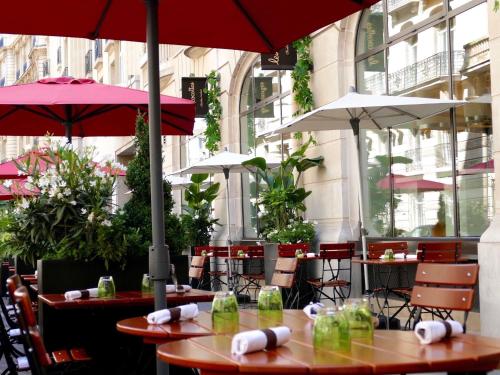 two tables with umbrellas in a restaurant at Sofitel Paris Arc De Triomphe in Paris