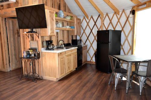 a kitchen with a black refrigerator and a table at Intimate Yurt Rental Ideal for Romantic Glamping in Virginia in Rich Creek