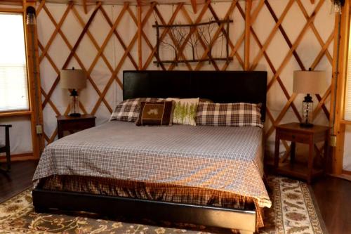 a bedroom with a bed and two night stands at Intimate Yurt Rental Ideal for Romantic Glamping in Virginia in Rich Creek