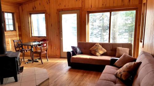 a living room with a couch and a table at Idyllic Lake Cabin for a Camping Getaway in Cross Wing County, Minnesota in Emily