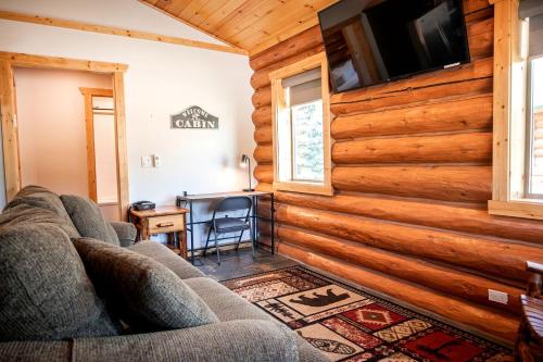 a living room with wooden walls and a couch at Luxury Pet-Friendly 1-Bedroom Log Cabin in Bonners Ferry with Full Kitchen and Wi-Fi in Bonners Ferry