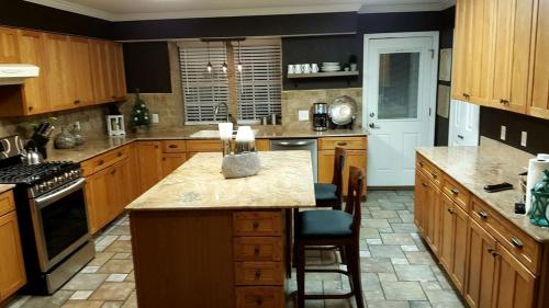 a large kitchen with wooden cabinets and a counter top at Beautiful Waterfront Cottage Rental with a Pool near New Orleans, Louisiana in Slidell