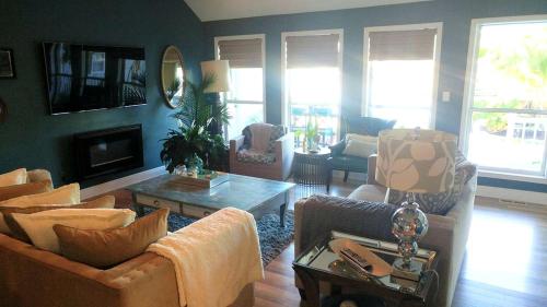 a living room with a couch and a table at Beautiful Waterfront Cottage Rental with a Pool near New Orleans, Louisiana in Slidell