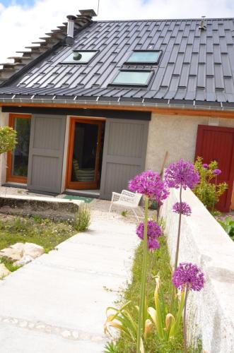 a house with purple flowers in front of it at Le Petit Chalande in Autrans
