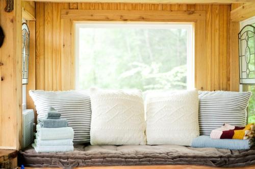a couch with white pillows in front of a window at Stunning Pet-Friendly Treehouse for Relaxing Glamping Retreats in North Carolina in Retreat