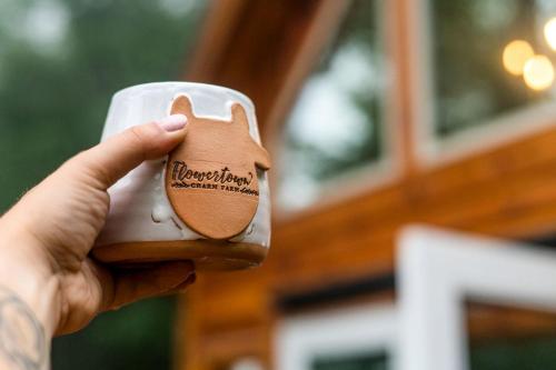 a hand holding a cup with a dog on it at Stunning Pet-Friendly Treehouse for Relaxing Glamping Retreats in North Carolina in Retreat