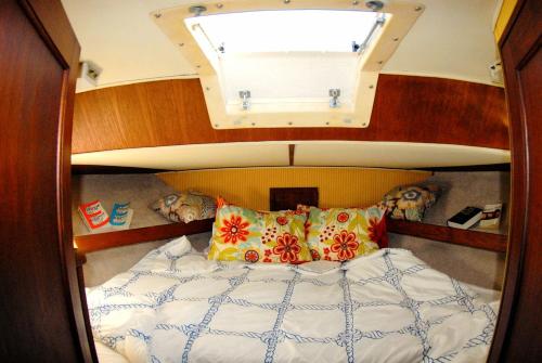 a bed in a boat with a window above it at Unique Yacht Rental in a Peaceful Setting on Damariscotta River, Maine in Newcastle