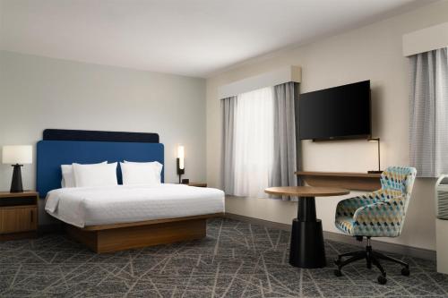 a hotel room with a bed and a desk and a chair at Hampton Inn & Suites Albuquerque North/I-25 in Albuquerque