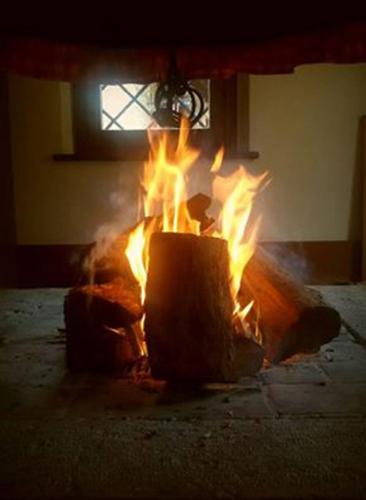 a fire is burning in a room with a window at Albergo Rurale Parco di San Floriano in Polcenigo