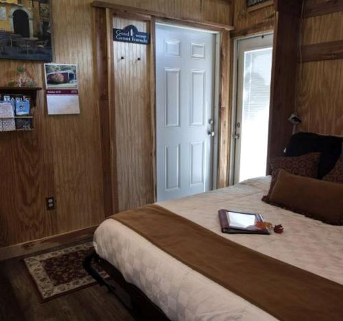 a bedroom with a bed with a tablet on it at Romantic Glamping Getaway with a Shared Hot Tub and Hiking Trails near Nashville, Tennessee in Gordonsville
