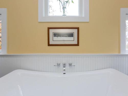 a bathroom with a sink and a picture on the wall at Exquisite Sunny Cabin Rental with a Hot Tub in Front Royal, Virginia in Warren Park