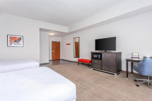 a hotel room with two beds and a flat screen tv at Hampton Inn Akron-South in Akron