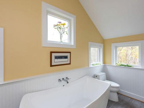 a bathroom with a tub and a toilet and a window at Exquisite Sunny Cabin Rental with a Hot Tub in Front Royal, Virginia in Warren Park
