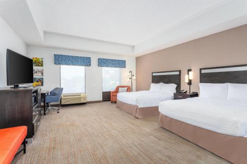 a hotel room with two beds and a flat screen tv at Hampton Inn Akron-South in Akron
