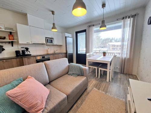 una sala de estar con un sofá y una mesa en Aurinkotuuli C9, en Kalajoki